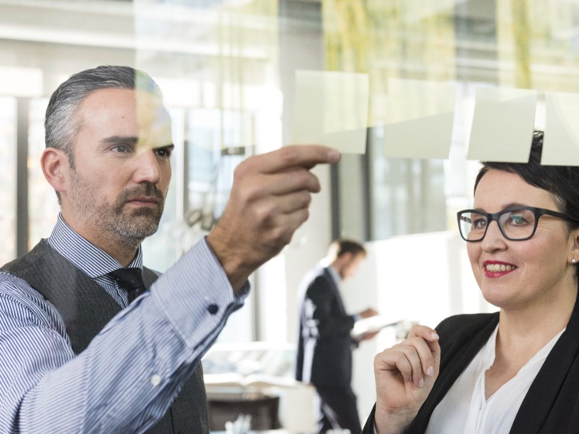 Man and woman making decisions using sticky notes at conference room, Fast Forward General Management & Administration