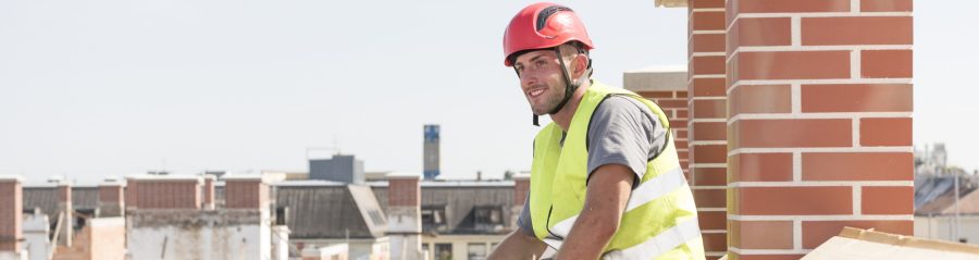 Smiling roofer sitting on roof