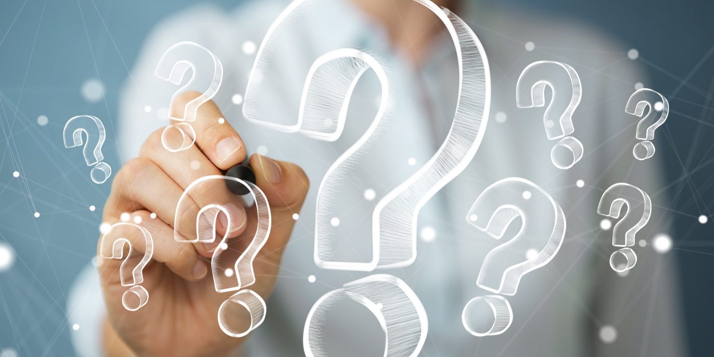 Businesswoman on blurred background drawing hand drawn question marks