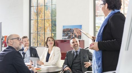 Woman at flip-chart during a presentation with other business people in a meeting room